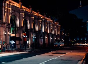 a city street at night with a building lit up