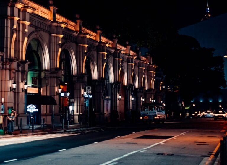 a city street at night with a building lit up