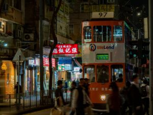 a double decker bus driving down a street at night