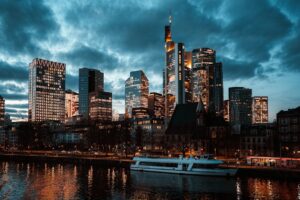 Modern cityscape with skyscrapers and river at dusk