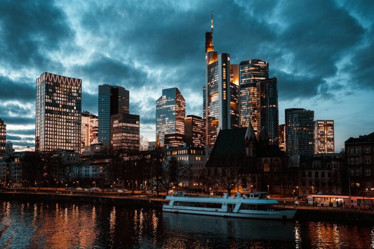 Modern cityscape with skyscrapers and river at dusk