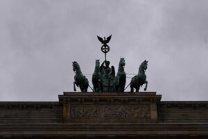 A statue on top of a building with horses on it