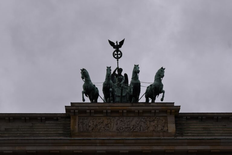 A statue on top of a building with horses on it
