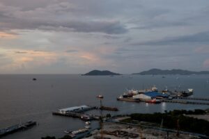 Ships docked at a harbor under a cloudy sky