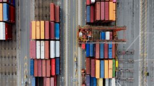 Aerial view of stacked shipping containers at a port.