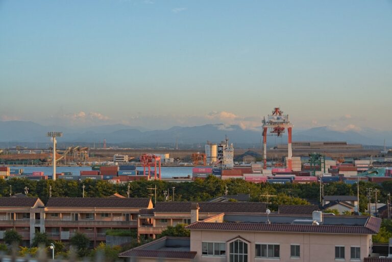Industrial port with cranes and containers under clear sky