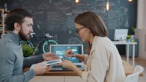 Two colleagues discussing a project at a desk.