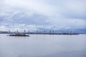 Industrial port with cranes under a cloudy sky