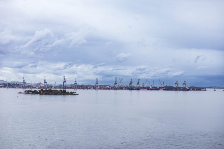 Industrial port with cranes under a cloudy sky
