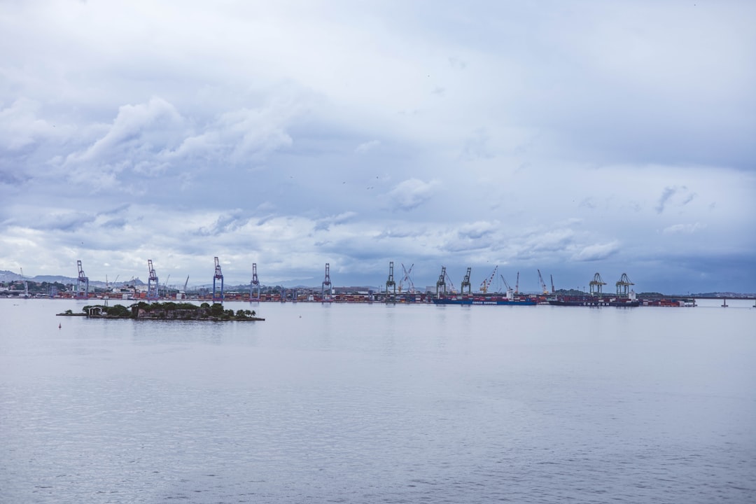 Industrial port with cranes under a cloudy sky