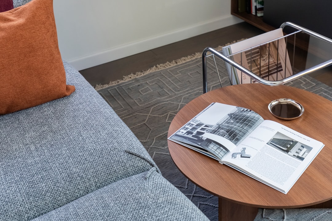 Modern living room with sofa, coffee table, and open book.