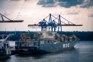 A cargo ship loads at a busy port.