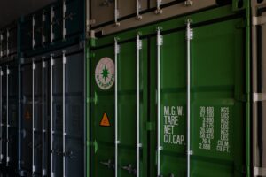 a row of green shipping containers sitting next to each other