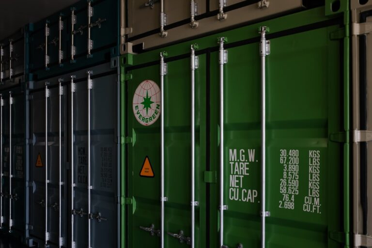 a row of green shipping containers sitting next to each other