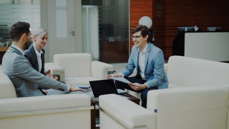 Three business people in a modern office meeting.
