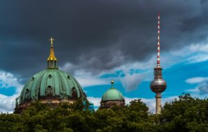 Berlin cathedral and television tower against dramatic skies.