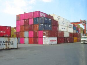 Stack of colorful shipping containers at a port.