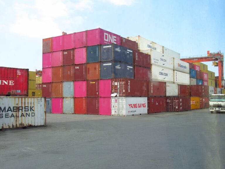 Stack of colorful shipping containers at a port.