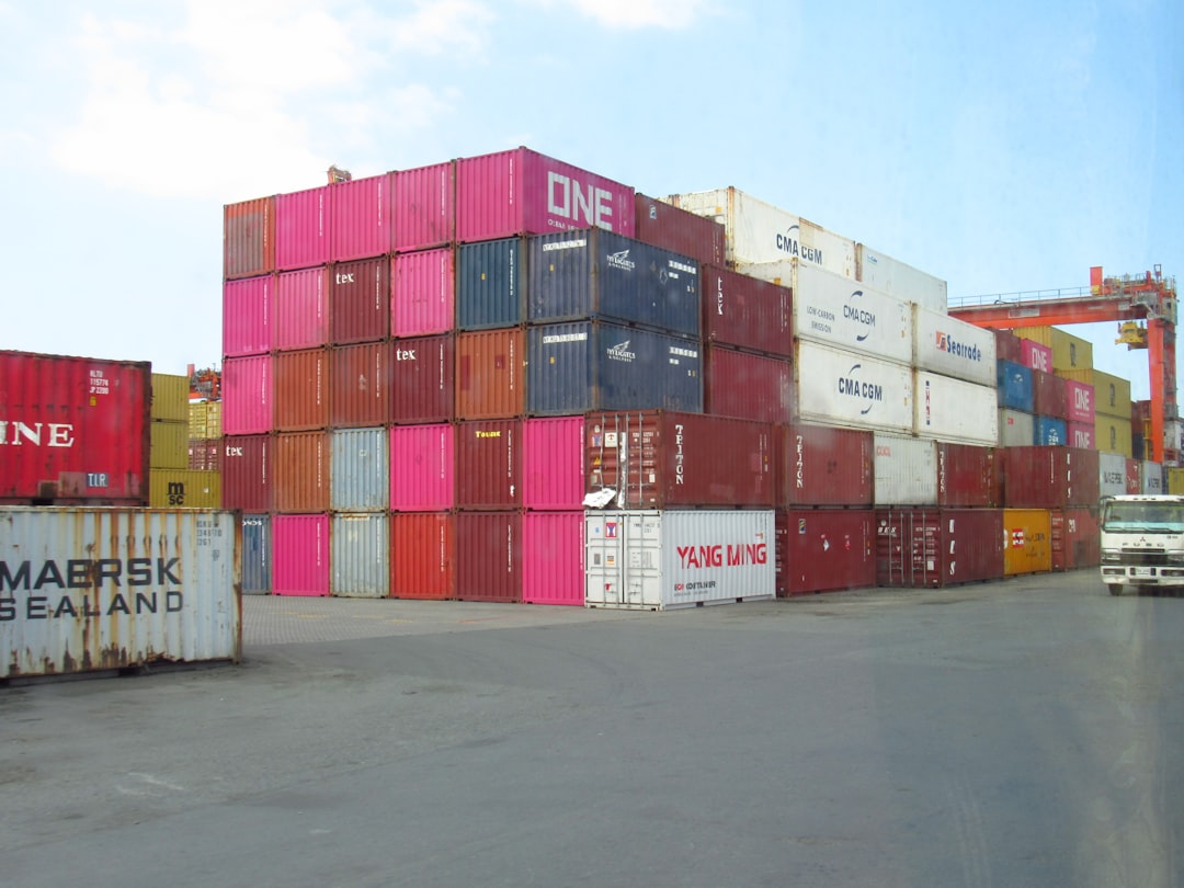 Stack of colorful shipping containers at a port.