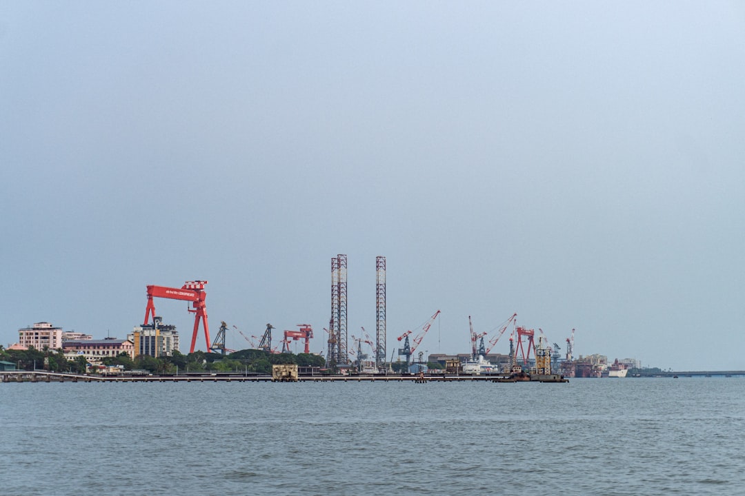 An industrial port with cranes and structures seen across water.