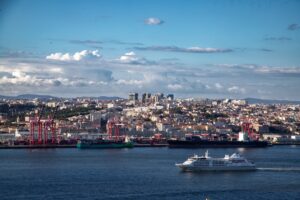 A city skyline overlooks a busy port with ships.