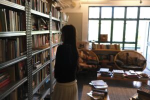 A woman browsing books on shelves in a cozy bookstore.