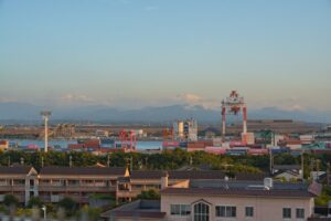 Industrial port with cranes and containers under clear sky