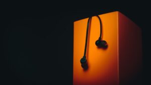 a pair of ear buds sitting on top of an orange box