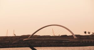 a person on a surfboard in front of a bridge