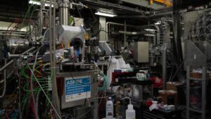 Complex laboratory with pipes, wires, and scientific equipment.